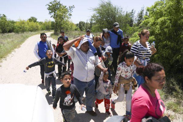 A group of illegal aliens walk up the road after crossing the Rio Grande from Mexico into McAllen, Texas, on April 18, 2019. (Charlotte Cuthbertson/The Epoch Times)