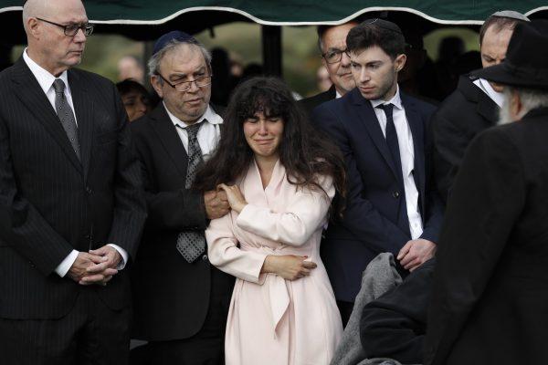 Hannah Kaye, the daughter of synagogue shooting victim Lori Kaye, center, holds the hand of her father, Howard Kaye, during funeral services, in San Diego, Calif., on April 29, 2019. (Gregory Bull/The Associated Press)