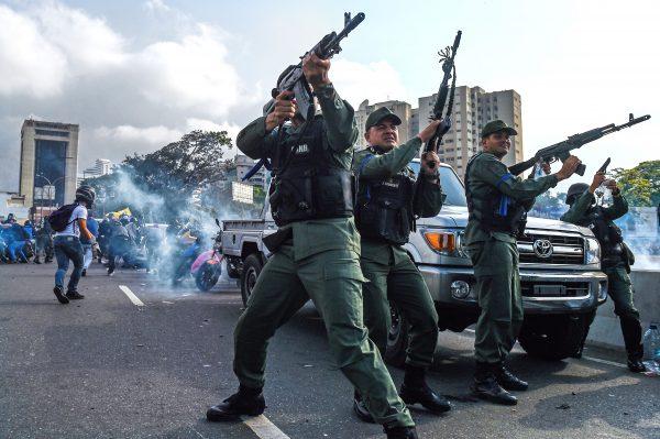 Members of the Bolivarian National Guard who joined Juan Guaidó fire into the air to repel forces loyal to Venezuelan regime leader Nicolas Maduro who arrived to disperse a demonstration near La Carlota military base in Caracas on April 30, 2019. (Federico Parra/AFP/Getty Images)