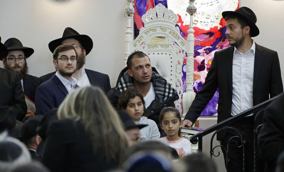 Almog Peretz, center, sits near his niece, Noya Dahan, 8, lower right, as they attend the funeral for Lori Kaye, at the Chabad of Poway synagogue in Poway, Calif., on April 29, 2019. (Gregory Bull/The Associated Press)