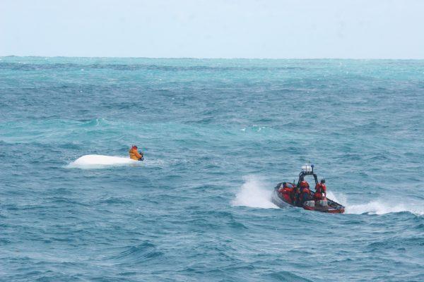 FILE—A Coast Guard boat approaches a man on a capsized boat, on March 2, 2009. (Adam Campbell/U.S. Coast Guard via Getty Images)