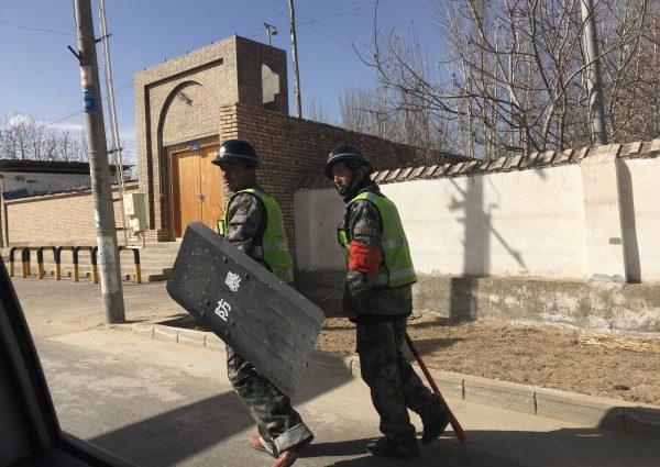 Local police patrol at a village in Hotan prefecture in China's western Xinjiang region on February 17, 2018. (BEN DOOLEY/AFP/Getty Images)