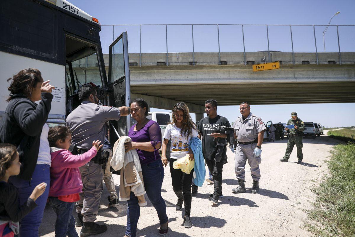 A large group of illegal aliens boards a bus bound for the Border Patrol processing facility after being apprehended by Border Patrol near McAllen, Texas, on April 18, 2019. (Charlotte Cuthbertson/The Epoch Times)