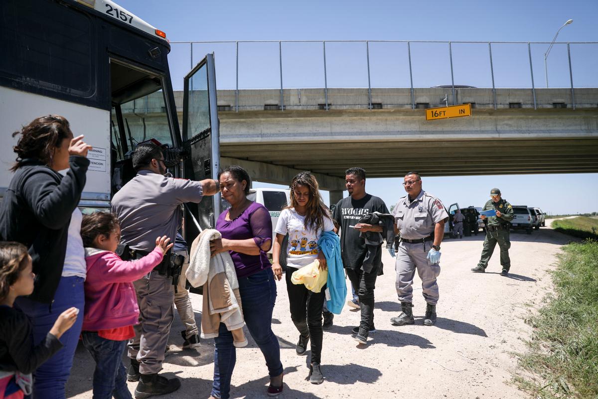  A large group of illegal aliens boards a bus bound for the Border Patrol processing facility after being apprehended by Border Patrol near McAllen, Texas, on April 18, 2019. (Charlotte Cuthbertson/The Epoch Times)