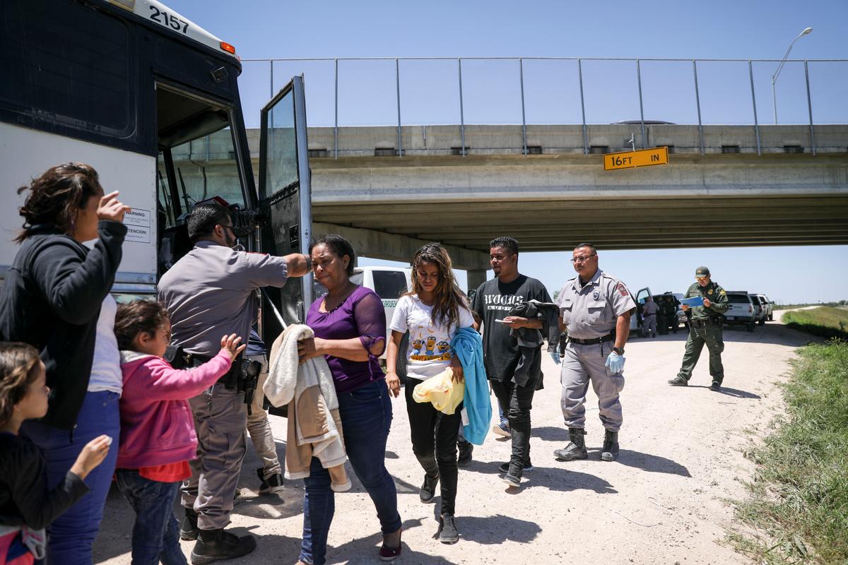 A large group of illegal aliens boards a bus bound for the Border Patrol processing facility after being apprehended by Border Patrol near McAllen, Texas, on April 18, 2019. (Charlotte Cuthbertson/The Epoch Times)