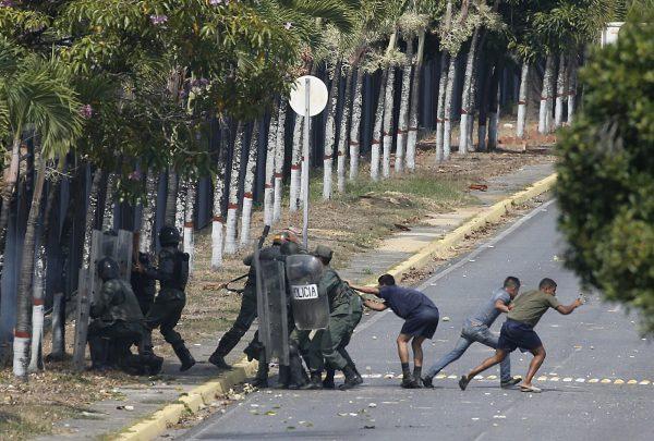 Security forces, some in civilian clothing, take positions inside La Carlota airbase during clashes with anti-government protesters in Caracas, Venezuela, on May 1, 2019. (Ariana Cubillos/AP Photo)