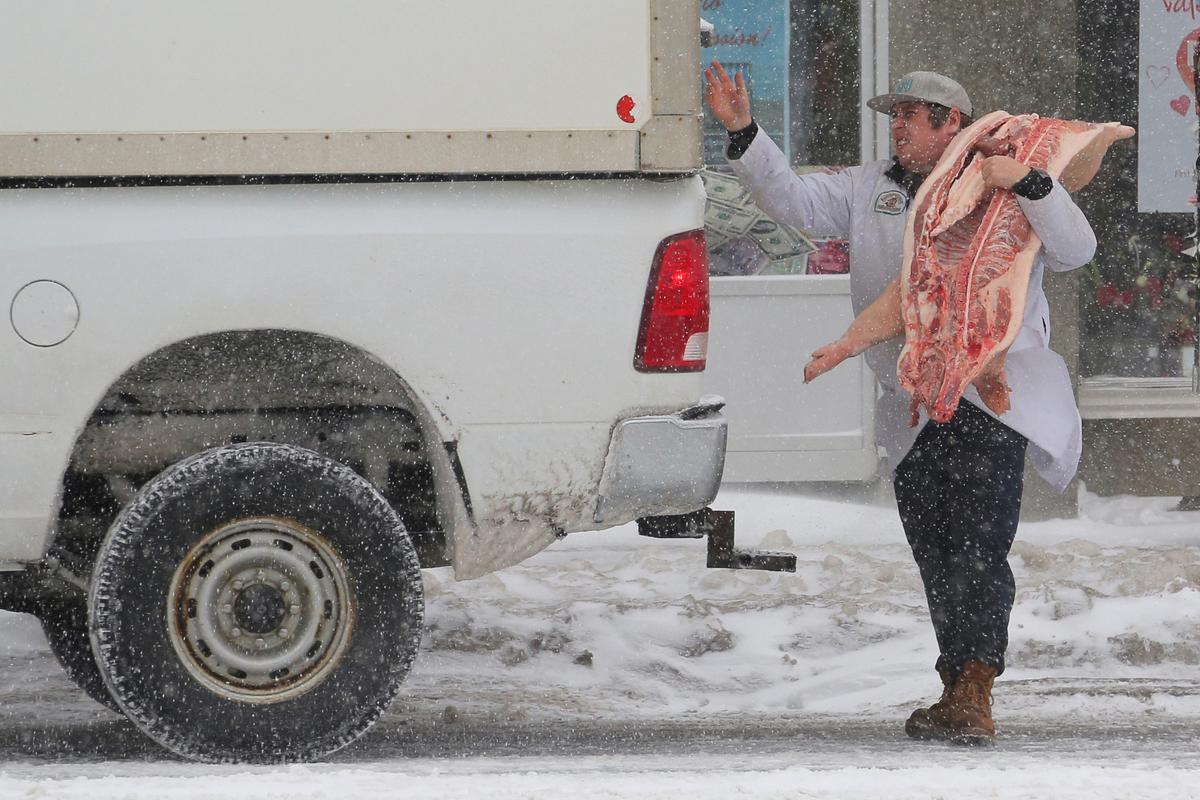 A butcher delivers pork during a snow storm in Toronto, Ontario, Canada, on Feb. 12, 2019. (Chris Helgren/Reuters)