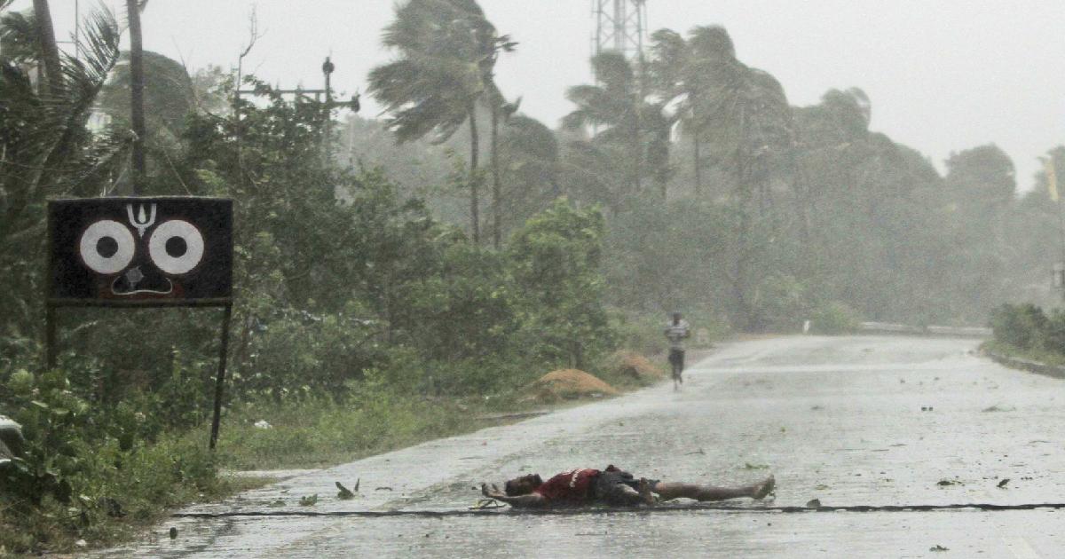 An Indian farmer lies on the road after falling while crossing the road due to gusty winds ahead of the landfall of cyclone Fani on the outskirts of Puri, in the Indian state of Odisha, Friday, May 3, 2019. (AP Photo)