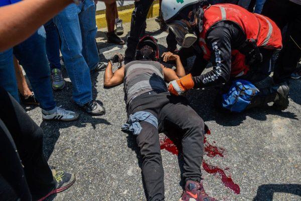 A demonstrator injured by Venezuelan security forces using an armored vehicle to ram demonstrators during clashes in the surroundings of La Carlota military base in Caracas, on April 30, 2019. (Federico Parra/AFP/Getty Images)