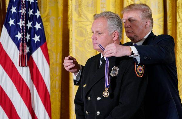 President Trump presents the Public Safety Medal of Valor Award to Firefighter/Harbor Patrol Officer David Poirier Jr., of the Redondo Beach, California, Fire Department during a ceremony in the East Room of the White House on Feb. 20, 2018. (Mandel Ngan/AFP/Getty Images)