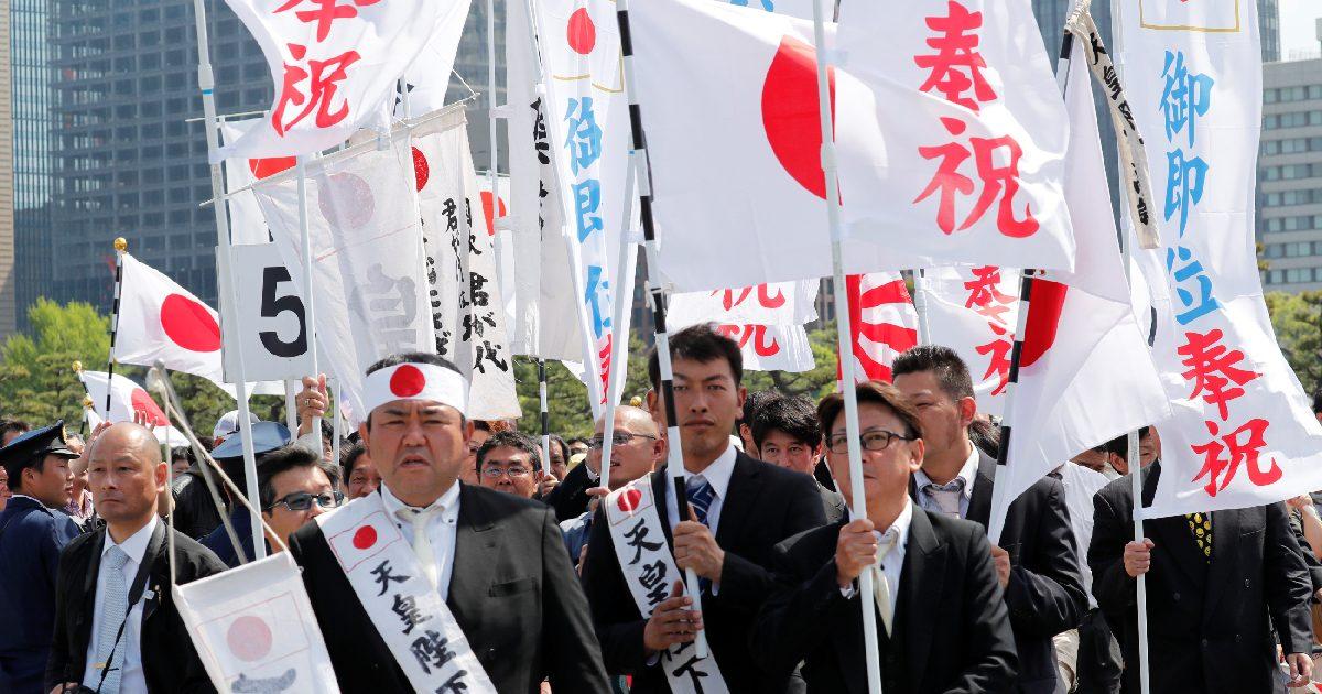 Well-wishers with flags wait in line to enter the royal palace before the first public appearance of Japan's head of state Naruhito and his wife Masako in Tokyo, Japan, on May 4, 2019. (Kim Kyung-Hoon/Reuters)