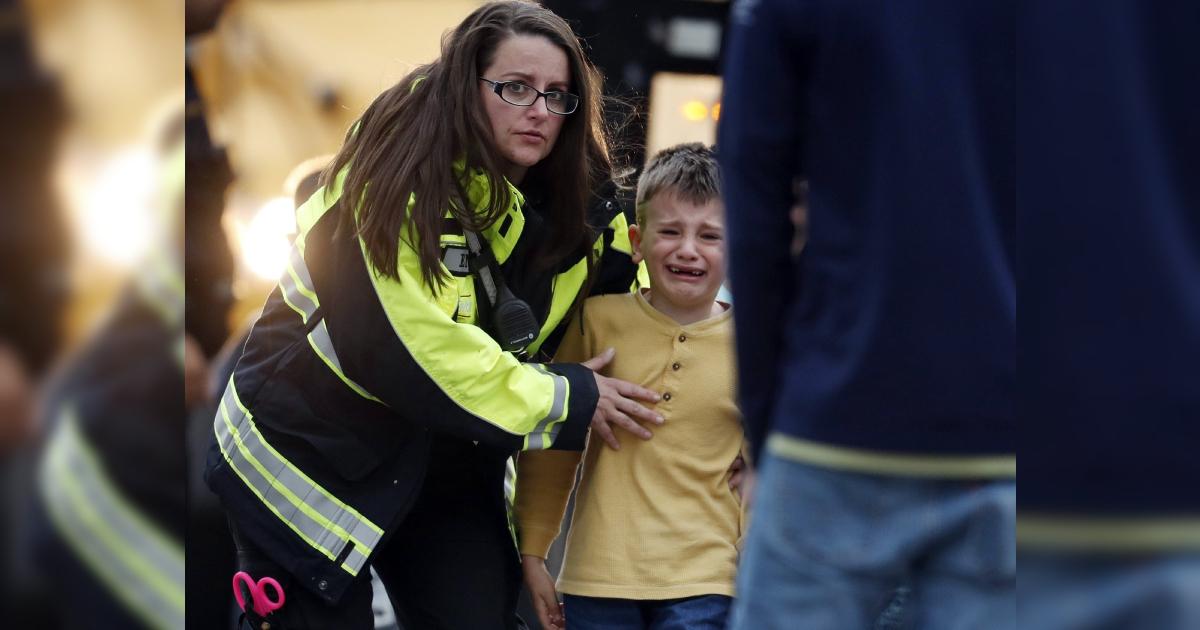 Officials guide students off a bus and into a recreation center where they were reunited with their parents after a shooting at a suburban Denver middle school in Highlands Ranch Colo. on May 7, 2019. (David Zalubowski/AP)