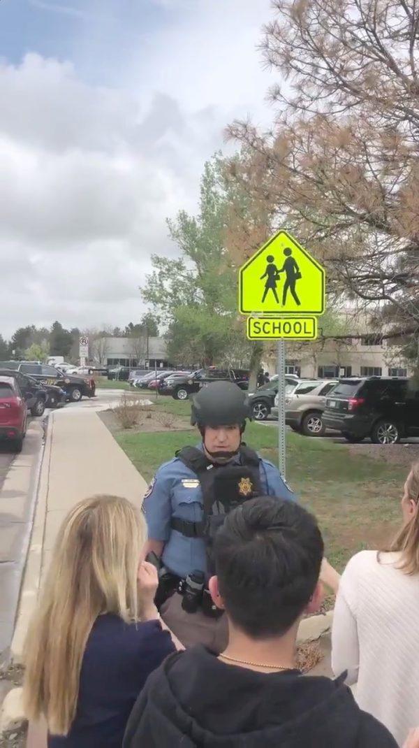 A police officer reassures people waiting outside near the STEM School during a shooting incident in Highlands Ranch, Colorado, on May 7, 2019. (Shreya Nallapati/via Reuters)