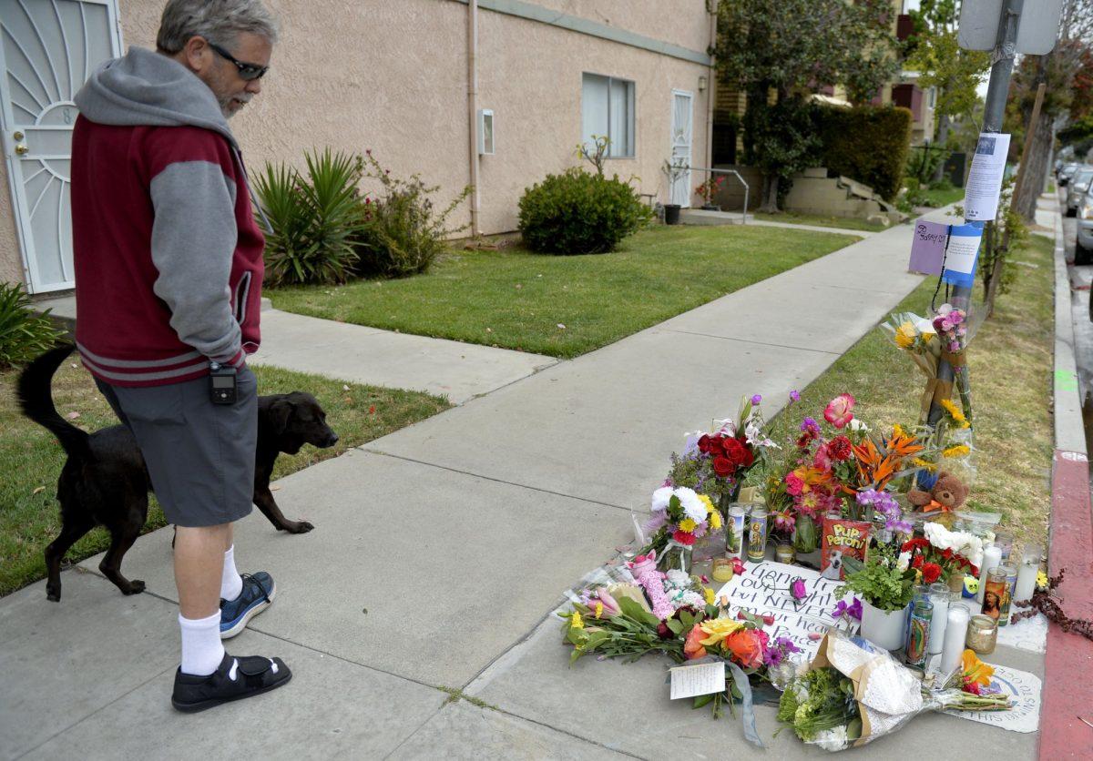 A man and his dog stop at the memorial for Jessica Bingaman in Long Beach, Calif., on May 8, 2019. (Brittany Murray/The Orange County Register via AP)