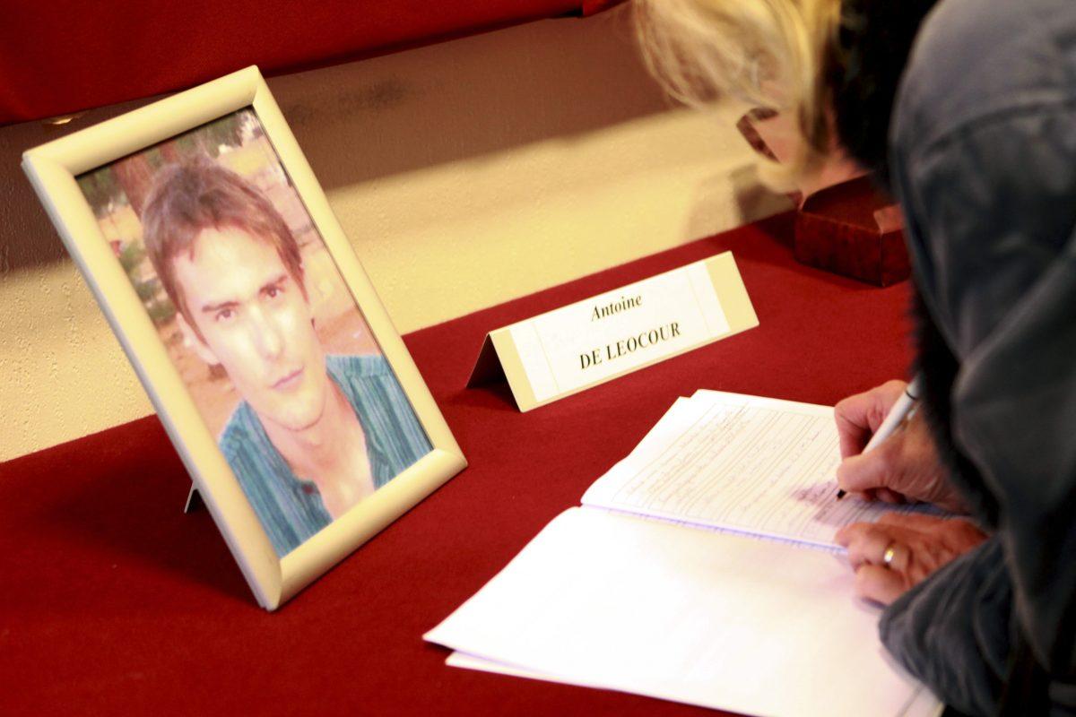 A man signs condolence books in memory of Antoine de Leocour and Vincent Delory (R), who were found dead, apparently executed by their kidnappers, after French special forces joined a failed attempt to rescue them in the African state of Niger, at Linselles' city hall in northern France on Jan. 10, 2011. (Luc Moleux/Reuters)