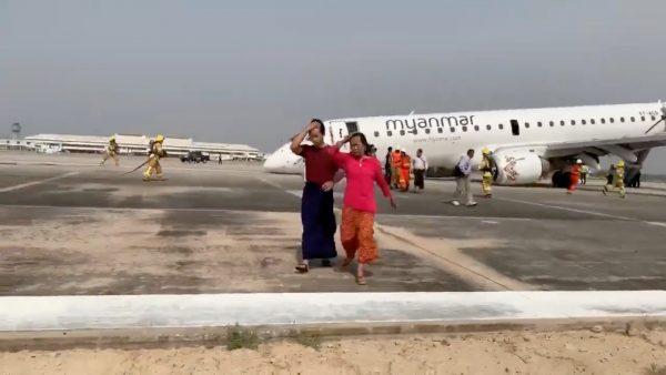 Passengers walk away from the plane after Myanmar National Airlines flight UB103 landed without a front wheel at Mandalay International Airport in Tada-u, Myanmar on May 12, 2019. (Nay Min via Reuters)