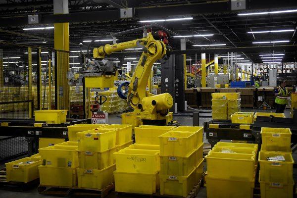 A 6-axis robotic arm picks up sorting containers at the Amazon fulfillment center in Baltimore, Md., on April 30, 2019. (Clodagh Kilcoyne/Reuters/File Photo)
