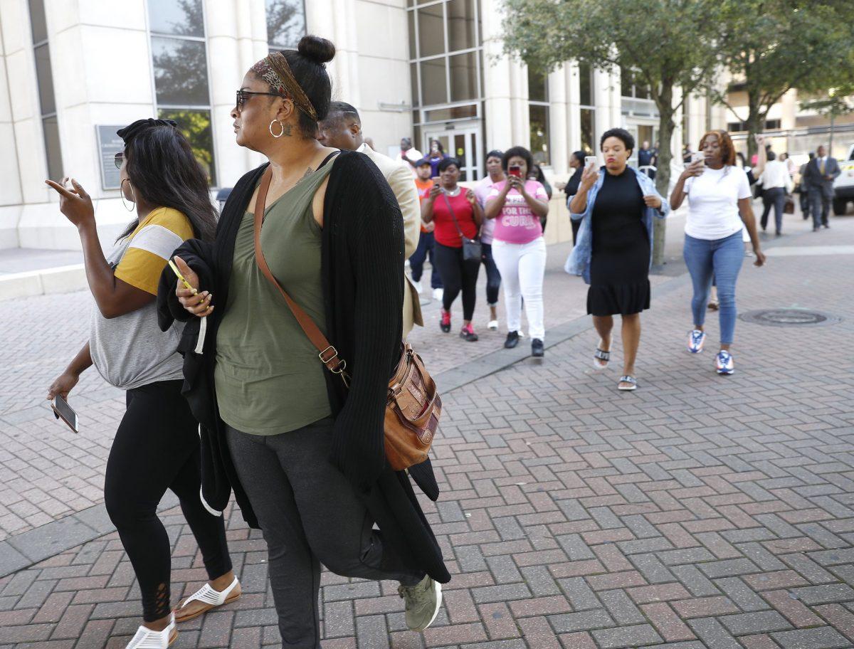 Brittany Bowens, the mother of the missing 4-year-old, Meleah Davis is followed down the street by protesters, after the court postponed a court appearance for Derion Vence, who is charged with tampering with evidence in the case of Meleah Davis' disappearance in Houston, on May 13, 2019. (Karen Warren/Houston Chronicle via AP)