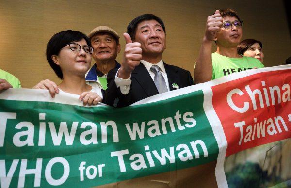 Taiwan's health Minister Chen Shih-chung (C) gives a thumb up as he poses with demonstrators after a press conference on the sidelines of the WHO's annual Assembly in Geneva, Switzerland, on May 21, 2018. (Fabrice Coffrini/AFP/Getty Images)