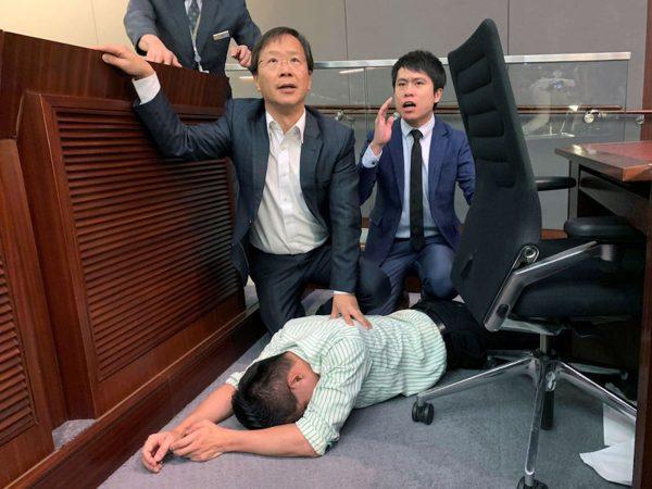 Pro-democracy lawmaker Gary Fan lies down after clashes with pro-Beijing lawmakers during a meeting over the controversial extradition bill, in Hong Kong, China on May 11, 2019. (James Pomfret/Reuters)