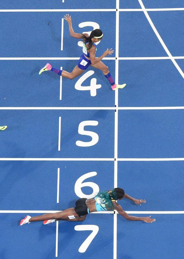 Bahamas' Shaunae Miller dives to cross the finish line ahead of USA's Chase Kalisz on Aug. 15, 2016. (Antonin Thuillier/AFP/Getty Images)