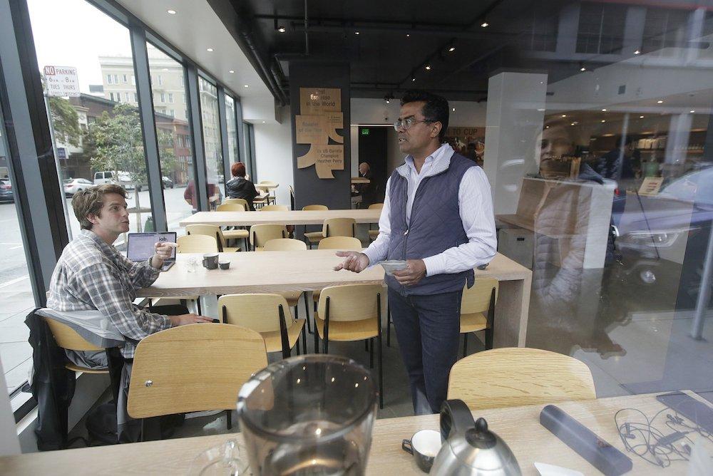 Klatch Coffee owner Bo Thiara (C), talks with customer Daniel Karel after giving Karel a tasting of Elida Natural Geisha coffee at his shop in San Francisco, on May 15, 2019. (AP Photo/Jeff Chiu)