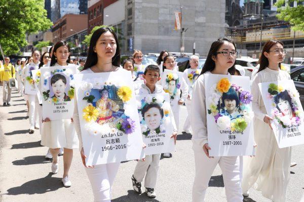 Falun Dafa practitioners carry placards bearing images of victims who died from persecution in China, during the World Falun Dafa Day parade in New York on May 16, 2019. (Samira Bouaou/The Epoch Times)