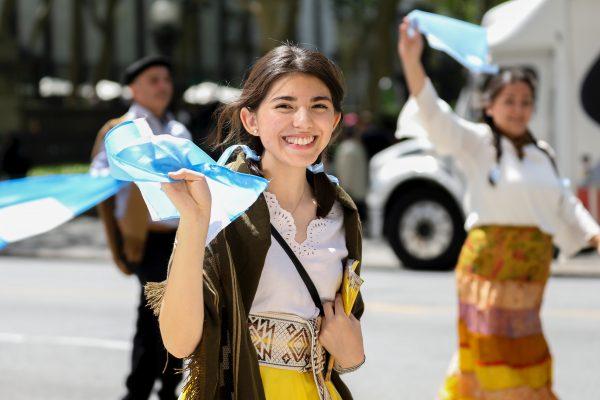 A Falun Dafa practitioner wearing traditional Argentinian dress waves during the parade in Manhattan on May 16, 2019. (Samira Bouaou/The Epoch Times)