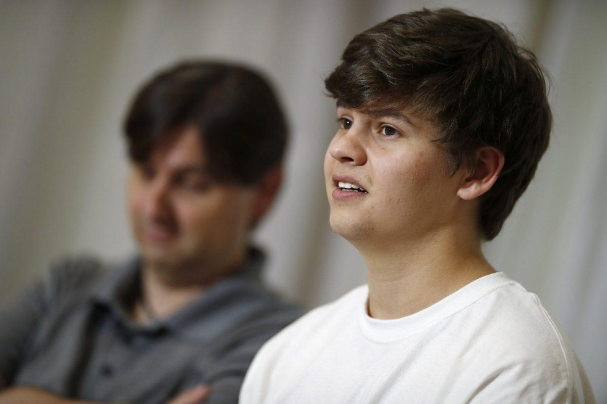 Joshua Jones, front, who was wounded while trying to stop a gunman involved in the attack on the STEM School Highlands Ranch last week, speaks during a news conference as his father, David, listens in Littleton, Colo., on May 14, 2019. (David Zalubowski/AP Photo)