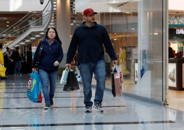 People walk with shopping bags at Roosevelt Field mall in Garden City, N.Y., on Dec. 7, 2018. (Shannon Stapleton/Reuters)