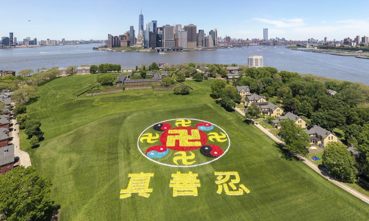 Thousands of Falun Gong practitioners came together on New York City's Governors Island for the character-formation event on May 18, 2019. The emblem consists of ancient symbols, the yellow Srivatsa symbolizing Buddhism and the red-black and red-blue Taiji symbols representing Taoism. (NTD)
