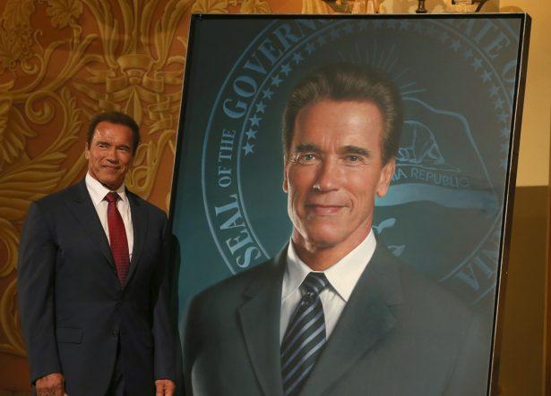 Former California Gov. Arnold Schwarzenegger poses next to his gubernatorial portrait at the unveiling in the Rotunda of the State Capitol in Sacramento, Calif., on Sept. 8, 2014. (Justin Sullivan/Getty Images)