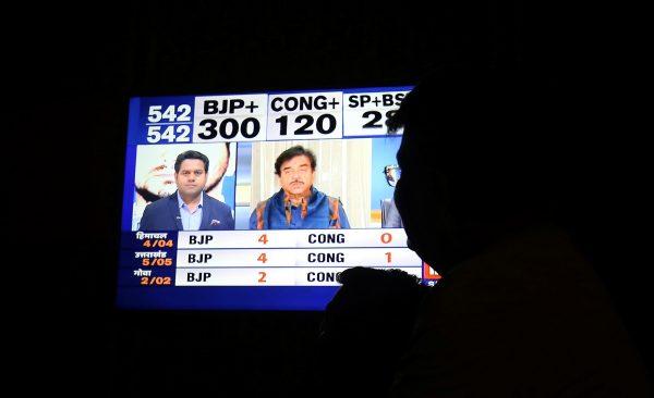 A man looks at a television screen showing exit poll results after the last phase of the general election in Ahmedabad, India, on May 19, 2019. (Amit Dave/Reuters)