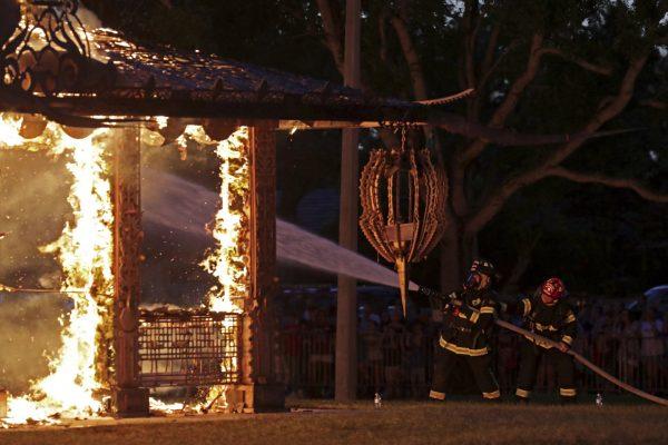 Firefighters try to control the flames during a ceremonial burn of the "Temple of Time" built as a memorial to the 17 victims of a shooting at Marjory Stoneman Douglas High School, in Coral Springs, Fla., on May 19, 2019. (John McCall/South Florida Sun-Sentinel via AP)