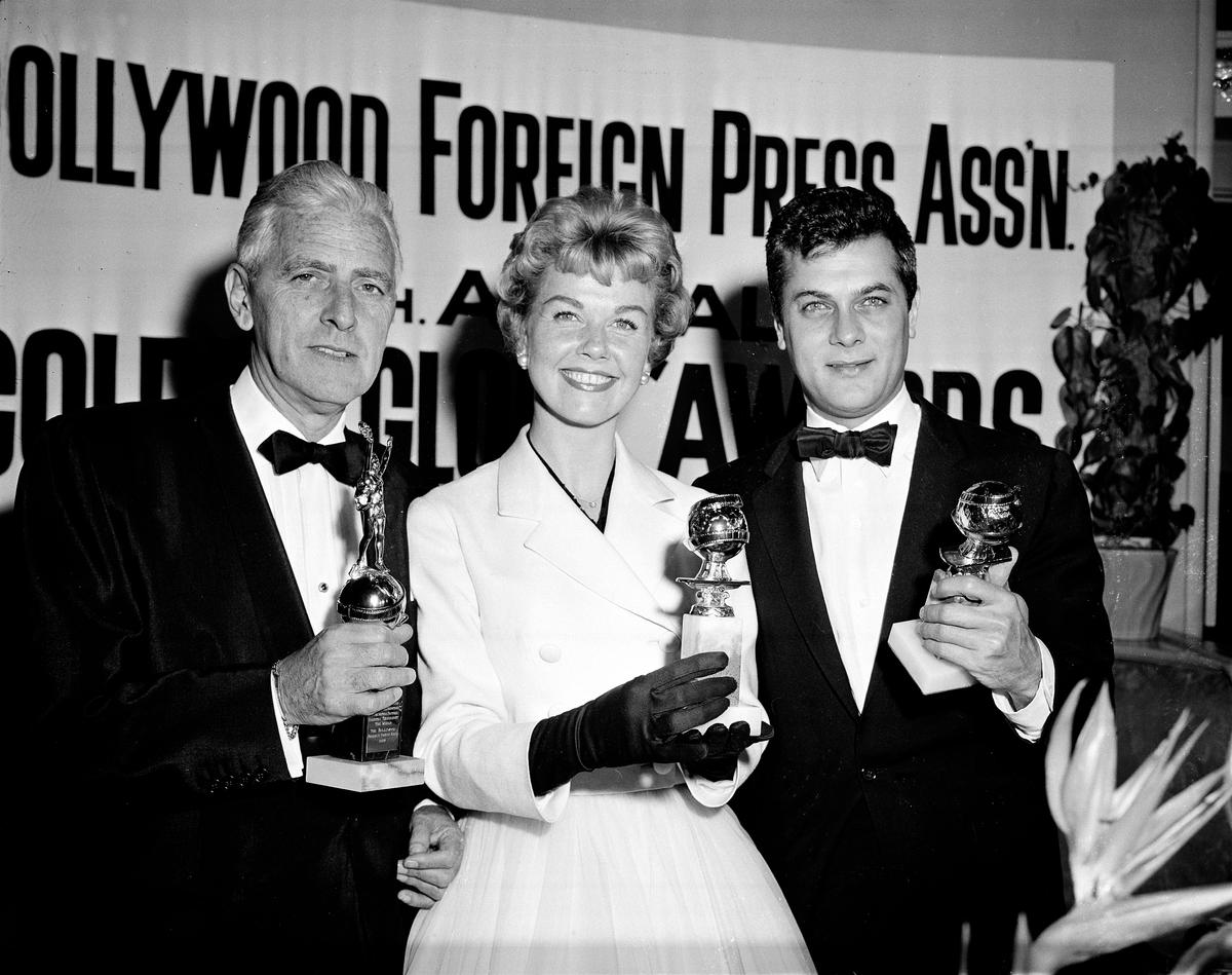 Doris Day with Buddy Adler (L) and Tony Curtis (R) posing with their awards (©AP Photo)
