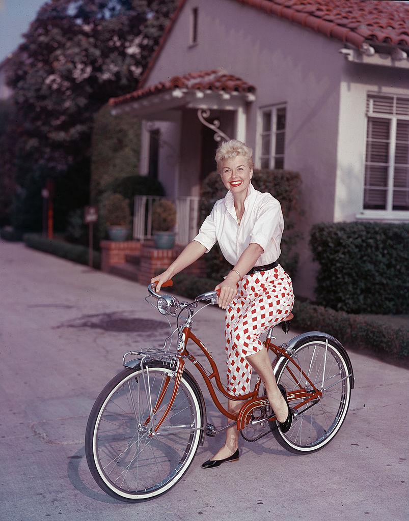 Doris Day poses on a red Schwinn bicycle in the late 1950s (©Getty Images | <a href="https://www.gettyimages.com/detail/news-photo/american-actor-doris-day-poses-on-a-red-schwinn-bicycle-news-photo/3342395?adppopup=true">Hulton Archive</a>)
