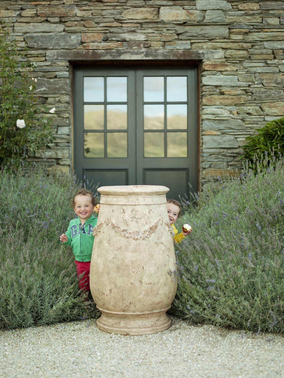 Fourbet's 3-year-old twins, Mortimer (L) and Augustin, hide behind one of his olive jars. (Rachael McKenna)