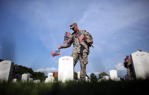Members of the 3rd U.S. Infantry Regiment place American flags at the graves of U.S. soldiers buried in Section 60 at Arlington National Cemetery in preparation for Memorial Day May 24, 2012 in Arlington, Virginia. (Win McNamee/Getty Images)
