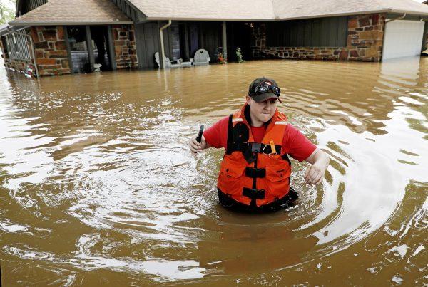 Tulsa County Sheriff's Deputy Miranda Munson makes her way back to a fan boat after checking a flooded house for occupants in the Town and Country neighborhood in Sand Springs, Okla., on May 23, 2019. (Mike Simons/Tulsa World via AP)