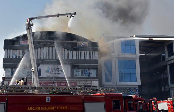 Firefighters douse a fire that broke out in a four-story commercial building in Surat, in the western state of Gujarat, India, on May 24, 2019. (Stringer/Reuters)
