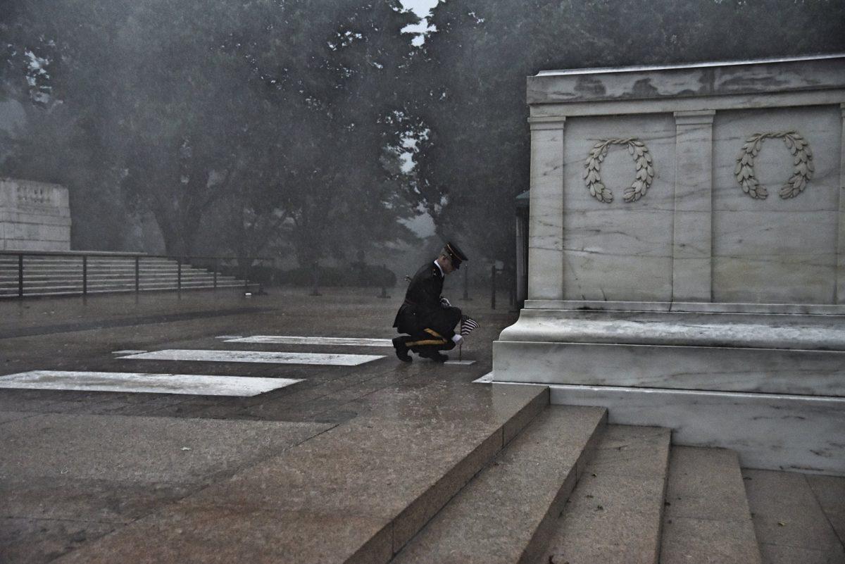 A Soldier of the 3d U.S. Infantry Regiment (The Old Guard) plants a U.S. flag in front of the Tomb of the Unknown Soldier during a severe storm for Flags In at Arlington National Cemetery, May 23, 2019. (U.S. Army photo by Sgt. Maryam Treece)