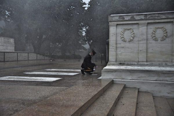 A Soldier of the 3d U.S. Infantry Regiment (The Old Guard) plants a U.S. flag in front of the Tomb of the Unknown Soldier during a severe storm for Flags In at Arlington National Cemetery, May 23, 2019. (U.S. Army photo by Sgt. Maryam Treece)