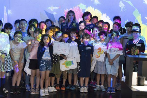 U.S. First Lady Melania Trump poses with Akie Abe, center right, wife of Japanese Prime Minister Shinzo Abe, and children for a photo during a visit to a digital art museum in Tokyo, Japan on May 26, 2019. (Pierre-Emmanuel Deletree/Pool Photo via AP)