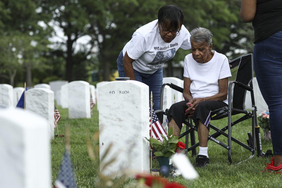 People pay respects to a fallen soldier in Arlington Cemetery in Arlington, Va., on May 26, 2019. (Samira Bouaou/The Epoch Times)