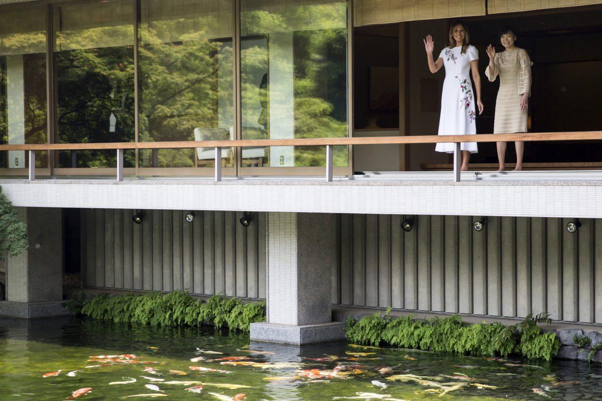 First Lady Melania Trump and Akie Abe, wife of Japanese Prime Minister Shinzo Abe wave after looking at koi carps in a pond at the Japanese style annex inside the State Guest House in Tokyo on May 27, 2019. (Tomohiro Ohsumi/AFP/Getty Images)