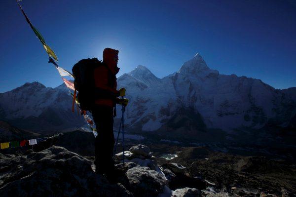 A trekker stands in front of Mount Everest, which is 8,850 meters high (C), at Kala Patthar in Solukhumbu District May 7, 2014. (Navesh Chitrakar/Reuters)