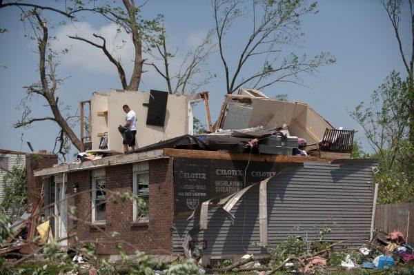 Residents in the West Brook neighborhood cut tree limbs and pick up scattered debris the morning after a suspected EF-4 tornado touched down early in the morning in Trotwood, Ohio on May 28, 2019. (Matthew Hatcher/Getty Images)