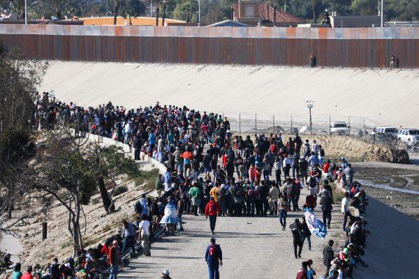  Migrants begin to retreat as U.S. law enforcement uses tear gas to repel their efforts to cross illegally into the United States, just west of the San Ysidro crossing in Tijuana, Mexico, on Nov. 25, 2018. (Charlotte Cuthbertson/The Epoch Times)
