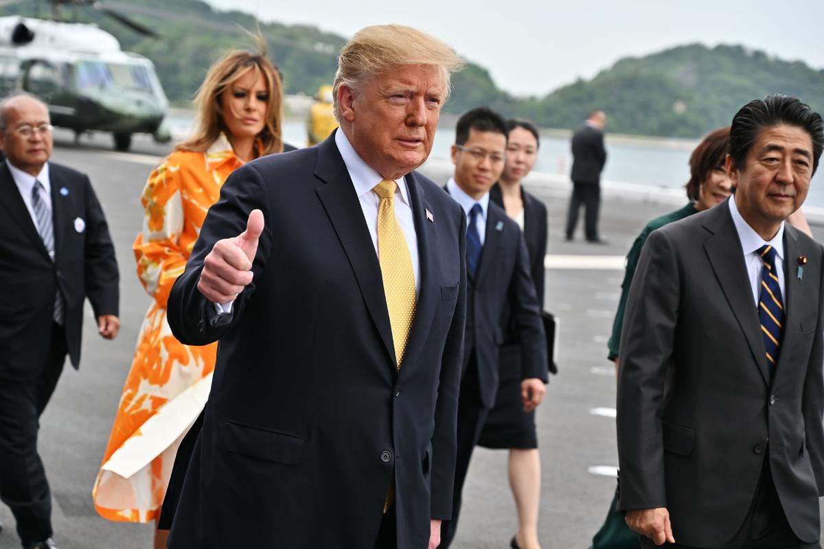 President Donald Trump and first lady Melania (2nd-L) arrive with Japan's Prime Minister Shinzo Abe (R) and his wife Akie (partly seen-R) onboard Japan's navy ship Kaga in Yokosuka on May 28, 2019. (CHARLY TRIBALLEAU/AFP/Getty Images)