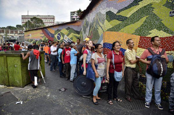 People queue to receive drums to collect water and water purification tablets from members of the Venezuelan Red Cross in Caracas, Venezuela, on April 16, 2019. (Yuri Corteza/AFP/Getty Images)